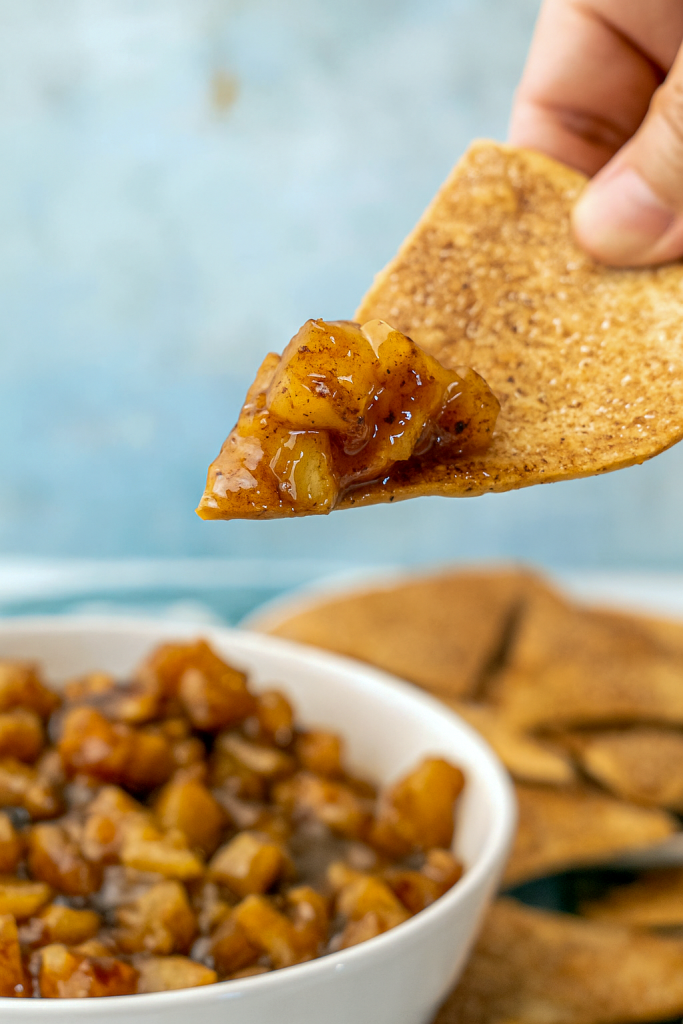 Close-up of a bowl of Dessert Salsa Apple Pie Dip surrounded by homemade Fall Salsa chips, showcasing an inventive Thanksgiving Recipes With A Twist, doubling as a Breakfast Dip Recipes delight and Thanksgiving Dessert Apple treat, perfect Apple Pie Dip For Party, a Fall Fruit Dip, one of the best Sweet Dips For Parties Fall, and ideal for Cute Thanksgiving Food Ideas.