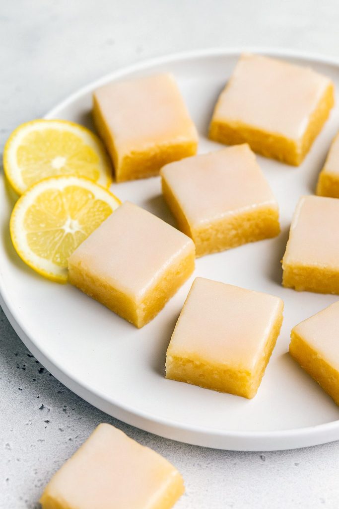 Close-up of Lemon Blondie Brownies showing their gooey, Moist Lemon Brownies interior; a drizzle of glaze highlights the Fudgy Lemon Brownies texture and Tangy Lemon Brownies flavor—perfect inspiration for How To Make Lemon Brownies, Lemon Brownies, Lemon Bar Cookies, Lemon Bars Recipe, and other Lemon Dessert Recipes.