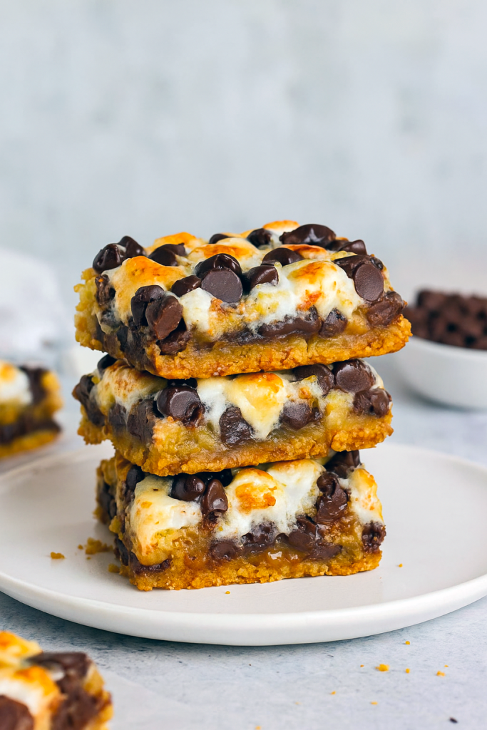 Layered Smores Bars in a pan showcasing gooey chocolate, marshmallows, and cookie layers—ideal Potluck Treats that double as Smores Squares and Bars For Potluck.