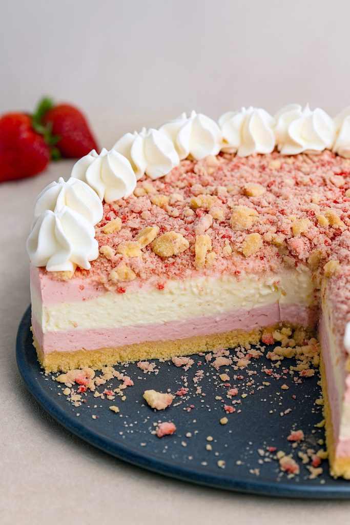 Close-up of a slice of Strawberry Crunch Cheesecake Cake, layered with creamy filling and crunchy topping, resembling a perfect Strawberry Crunch Crumble Recipe in bar form—a stunning take on Dessert Recipes Cheesecake. The vibrant pink layers highlight the irresistible Strawberry Crunch Cheesecake Bars ready to tempt every sweet tooth.