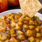 Close-up of a bowl of Dessert Salsa Apple Pie Dip surrounded by homemade Fall Salsa chips, showcasing an inventive Thanksgiving Recipes With A Twist, doubling as a Breakfast Dip Recipes delight and Thanksgiving Dessert Apple treat, perfect Apple Pie Dip For Party, a Fall Fruit Dip, one of the best Sweet Dips For Parties Fall, and ideal for Cute Thanksgiving Food Ideas.