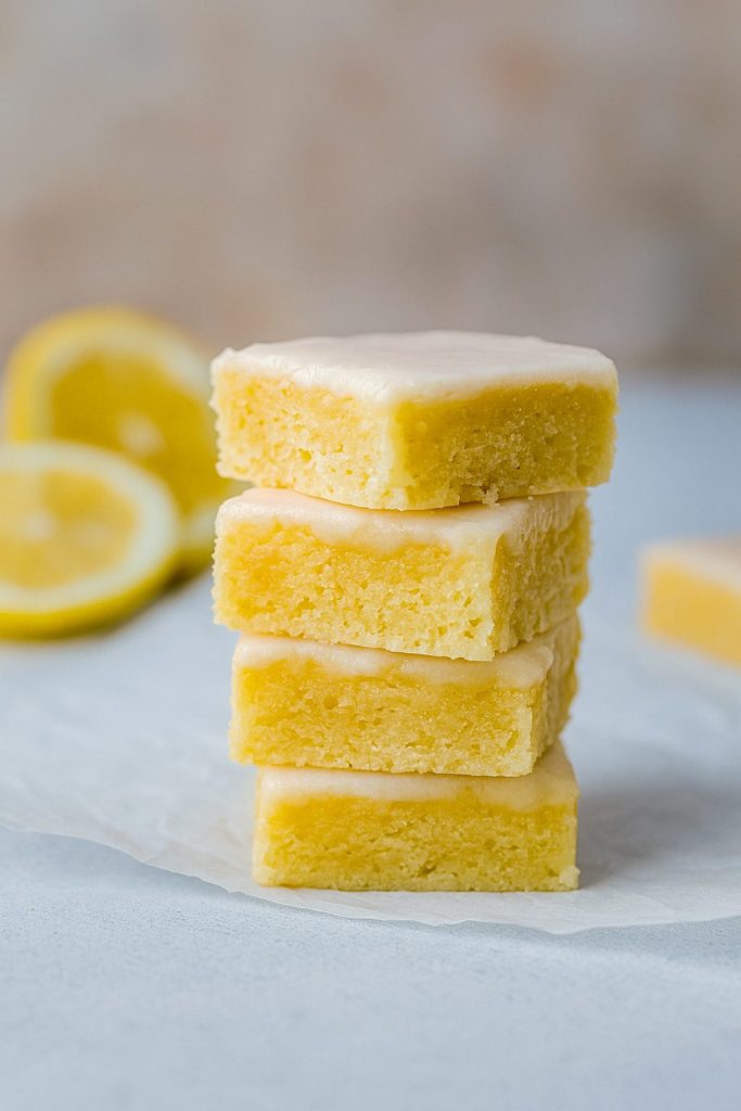 Close-up of Lemon Blondie Brownies showing their gooey, Moist Lemon Brownies interior; a drizzle of glaze highlights the Fudgy Lemon Brownies texture and Tangy Lemon Brownies flavor—perfect inspiration for How To Make Lemon Brownies, Lemon Brownies, Lemon Bar Cookies, Lemon Bars Recipe, and other Lemon Dessert Recipes.