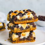 Layered Smores Bars in a pan showcasing gooey chocolate, marshmallows, and cookie layers—ideal Potluck Treats that double as Smores Squares and Bars For Potluck.