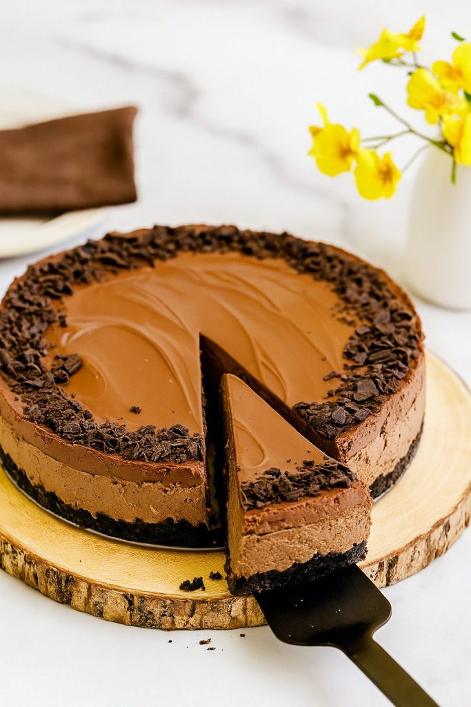A rich and decadent No Bake Chocolate Chip Oreo Ganache Cheesecake with a smooth chocolate ganache topping and Oreo crust, showcasing a slice of Creamy Chocolate Cheesecake—perfect for anyone looking for Chocolate Cheesecake Recipes like Chocolate No Bake Cheesecake Simple or a festive No Bake Pumpkin Cheesecake alternative.
