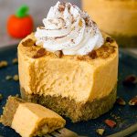 A row of mini no-bake pumpkin cheesecakes in paper cups, each showcasing creamy layers of Non Bake Pumpkin Cheesecake and Pumpkin Pie Cheesecake No Bake filling on a golden graham base, perfect for Easy Fall Deserts For A Party, Pumpkin Cheesecake For Two, Halloween Desserts No Bake, Thanksgiving Recipes Baking, Mexican Food Recipes Easy Dessert, and all your Fall Recipes Dessert Halloween cravings.