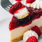 Close-up of a chilled pie slice in a buttery Biscuits Graham crust, showing the creamy filling and jewel-red raspberry topping—an elegant Dessert Aux Fruits plate presentation for lovers of classic Cheese Pies.
