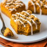 Overhead shot of a pan cut into Pumpkin Cheesecake Streusel Bars, each slice the texture of a mini Pumpkin Cheesecake Streusel Pie with a crisp gingersnap base reminiscent of Gingersnap Pumpkin Pie Bars or Pumpkin Pie Slab Bars, topped with a crumbly Streusel Bars layer, finished with a drizzle of Desserts Nutella, hinting at lighter Weight Watcher Desserts options, perfect as a play on Smores Dessert, packed full of Pumpkin Bars With Pumpkin Pie Spice flavor.